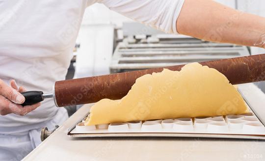 Rolling out cookie dough over a cookie cutter mold using a wooden rolling pin in a bakery, shaping the dough for cutting in a professional baking environment  : Stock Photo or Stock Video Download rcfotostock photos, images and assets rcfotostock | RC Photo Stock.:
