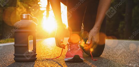 Runner woman trying running shoes getting ready for run with drinking bottle. Healthy lifestyle. Workout and diet concept.  : Stock Photo or Stock Video Download rcfotostock photos, images and assets rcfotostock | RC Photo Stock.:
