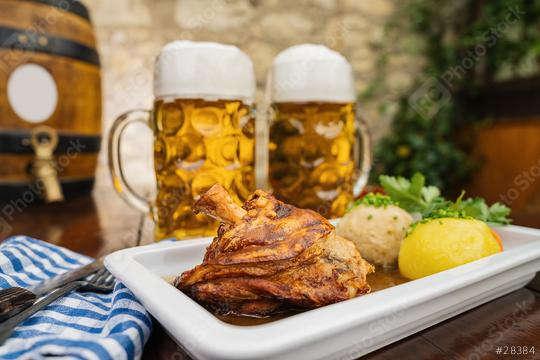 Schweinshaxe, traditional Bavarian cuisine with roasted ham hock (pork knuckle) with potato dumpling, brezen and tow beer glasses in a beer garden or oktoberfest  : Stock Photo or Stock Video Download rcfotostock photos, images and assets rcfotostock | RC Photo Stock.: