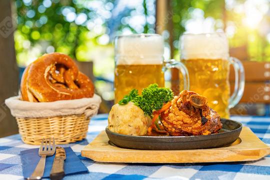 Schweinshaxe, traditional Bavarian cuisine with roasted ham hock (pork knuckle) with potato dumpling, brezen and beer mug on a table at beer garden or oktoberfest  : Stock Photo or Stock Video Download rcfotostock photos, images and assets rcfotostock | RC Photo Stock.: