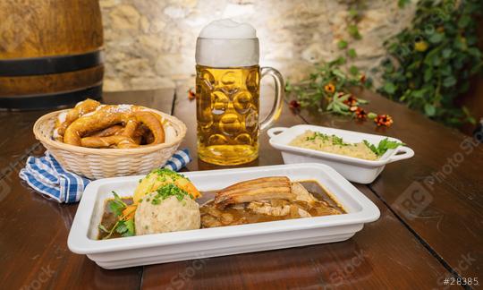 schweinskrustenbraten mit biersauce, in German cuisine, is a pork crust roast with beer sauce, with cabbage and potato dumpling, brezen and beer mug in a Bavarian beer garden or oktoberfest  : Stock Photo or Stock Video Download rcfotostock photos, images and assets rcfotostock | RC Photo Stock.: