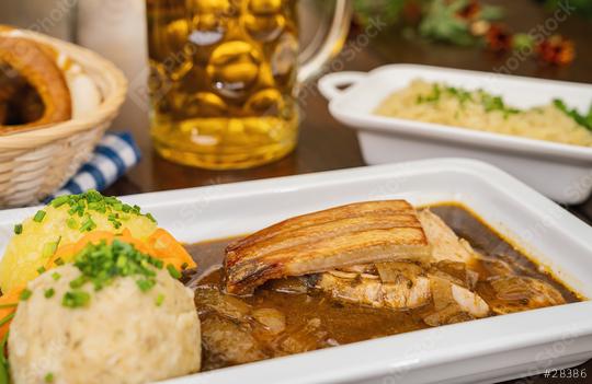 schweinskrustenbraten mit biersauce, in German cuisine, is a pork crust roast with beer sauce, with cabbage and potato dumpling, brezen and beer mug in a Bavarian beer garden or oktoberfest  : Stock Photo or Stock Video Download rcfotostock photos, images and assets rcfotostock | RC Photo Stock.: