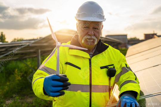 Senior engineer holding a wind turbine model at a solar plant. Alternative energy ecological concept.  : Stock Photo or Stock Video Download rcfotostock photos, images and assets rcfotostock | RC Photo Stock.: