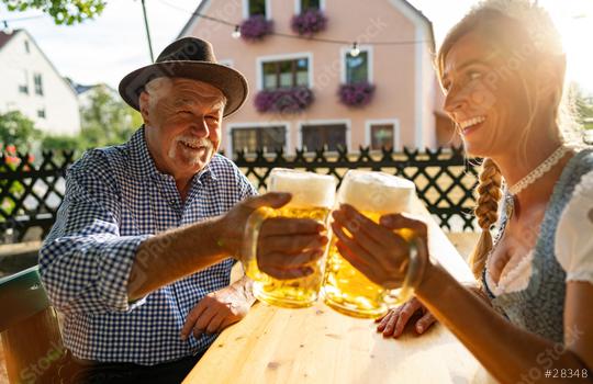 Senior man and woman in traditional clothing or tracht toasting beer mugs in beer garden or oktoberfest at Bavaria, Germany  : Stock Photo or Stock Video Download rcfotostock photos, images and assets rcfotostock | RC Photo Stock.: