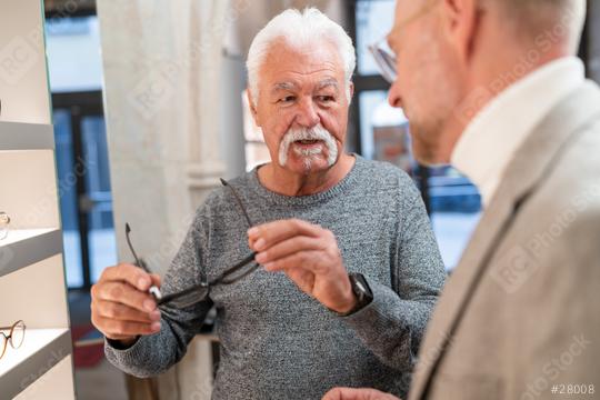 Senior man trying on new glasses and talks about it with an optician in store  : Stock Photo or Stock Video Download rcfotostock photos, images and assets rcfotostock | RC Photo Stock.: