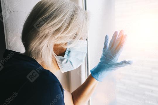 senior woman in wants to break out of isolation from corona COVID-19 quarantine looking out of window to the streets  : Stock Photo or Stock Video Download rcfotostock photos, images and assets rcfotostock | RC Photo Stock.: