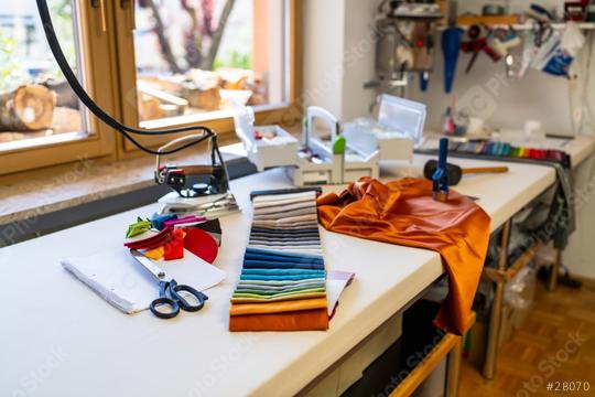 sewing or tailoring workshop showcases a table filled with sewing essentials: fabric swatches, scissors, iron, color palette, silk fabrics and tools, with a window displaying stacked firewood outside  : Stock Photo or Stock Video Download rcfotostock photos, images and assets rcfotostock | RC Photo Stock.: