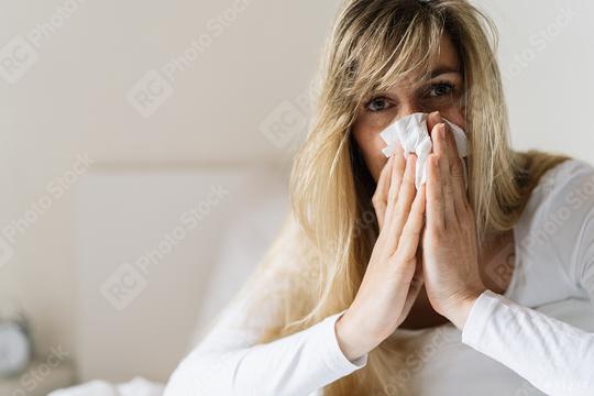 Sick woman suffering from running stuffy nose and sore throat. Upset ill european lady sits in bed, blowing her nose using paper napkin tissue. Cold And Flu Concept  : Stock Photo or Stock Video Download rcfotostock photos, images and assets rcfotostock | RC Photo Stock.: