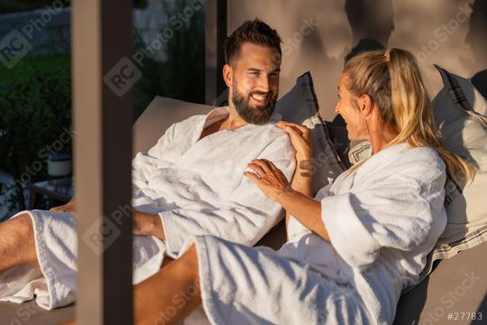 Smiling and talking couple in white bathrobes enjoying a conversation in the sunlight at spa hotel  : Stock Photo or Stock Video Download rcfotostock photos, images and assets rcfotostock | RC Photo Stock.: