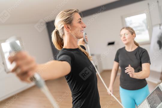 smiling female client holding body composition balance scale analysis handles for Inbody test with a trainer in the background at a gmy  : Stock Photo or Stock Video Download rcfotostock photos, images and assets rcfotostock | RC Photo Stock.: