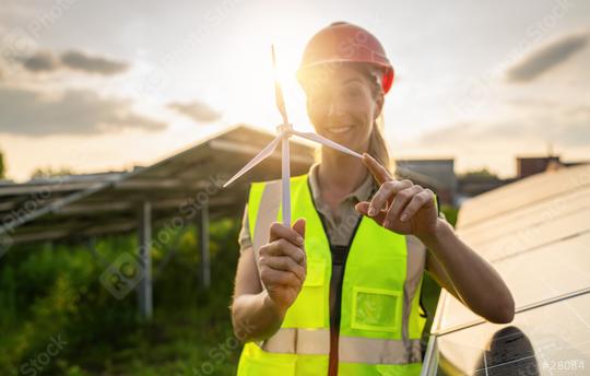 Smiling female engineer holding a wind turbine model at a solar farm. Alternative energy ecological concept image.  : Stock Photo or Stock Video Download rcfotostock photos, images and assets rcfotostock | RC Photo Stock.: