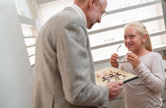 Smiling girl examining glasses with a optician assisting her by choosing eyeglasses in eyewear shop.  : Stock Photo or Stock Video Download rcfotostock photos, images and assets rcfotostock | RC Photo Stock.: