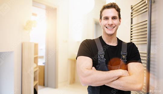 smiling handsome plumber standing with crossed arms and looking at camera in bathroom Room  : Stock Photo or Stock Video Download rcfotostock photos, images and assets rcfotostock | RC Photo Stock.: