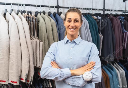 Smiling tailor with crossed arms in front of a rack of suits in a clothing store  : Stock Photo or Stock Video Download rcfotostock photos, images and assets rcfotostock | RC Photo Stock.: