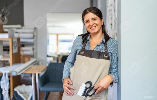 smiling tailor woman in a checkered shirt and beige apron stands in a workspace, holding a pair of scissors and a scale ruler in her apron pocket  : Stock Photo or Stock Video Download rcfotostock photos, images and assets rcfotostock | RC Photo Stock.: