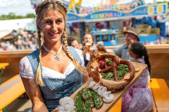 Smiling Waitress in traditional Bavarian dress or dirndl holding a wooden platter with traditional German food in a beer tent at  oktoberfest festival or dult in germany  : Stock Photo or Stock Video Download rcfotostock photos, images and assets rcfotostock | RC Photo Stock.: