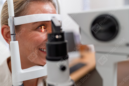 Smiling woman during eye exam with slit-lamp retinal reflection   : Stock Photo or Stock Video Download rcfotostock photos, images and assets rcfotostock | RC Photo Stock.: