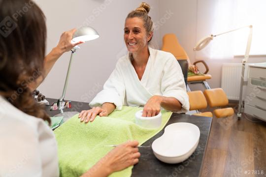 Smiling woman in a bathrobe getting a manicure at a nail salon. body care spa treatment concept image  : Stock Photo or Stock Video Download rcfotostock photos, images and assets rcfotostock | RC Photo Stock.: