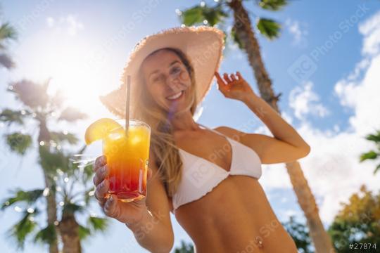 Smiling woman in white bikini and straw hat holding a tropical cocktail, palm trees, sunny sky at caribbean island  : Stock Photo or Stock Video Download rcfotostock photos, images and assets rcfotostock | RC Photo Stock.: