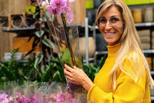 Smiling woman with glasses admiring Fresh pink Orchid flowers in a Garden Center for Purchase. Shopping in a greenhouse concept image  : Stock Photo or Stock Video Download rcfotostock photos, images and assets rcfotostock | RC Photo Stock.: