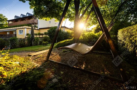 Sunlight peeks through trees onto a wicker garden swing at dawn  : Stock Photo or Stock Video Download rcfotostock photos, images and assets rcfotostock | RC Photo Stock.: