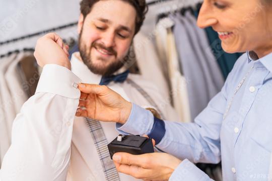 Tailor assisting a client with cufflinks, both are smiling  : Stock Photo or Stock Video Download rcfotostock photos, images and assets rcfotostock | RC Photo Stock.: