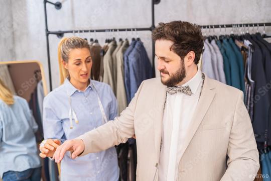 Tailor examining sleeve length on a man