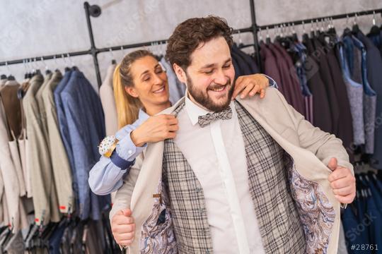 Tailor helping a man try on a jacket in a boutique, both are smiling  : Stock Photo or Stock Video Download rcfotostock photos, images and assets rcfotostock | RC Photo Stock.: