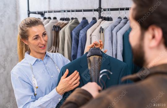 Tailor holding a teal jacket for a male client, both engaging in conversation at a store  : Stock Photo or Stock Video Download rcfotostock photos, images and assets rcfotostock | RC Photo Stock.: