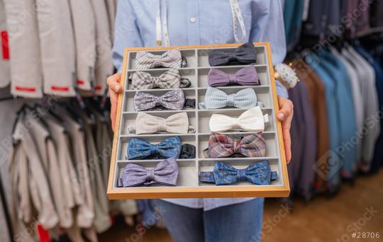 Tailor presenting a selection of bow ties in a compartmentalized tray  : Stock Photo or Stock Video Download rcfotostock photos, images and assets rcfotostock | RC Photo Stock.: