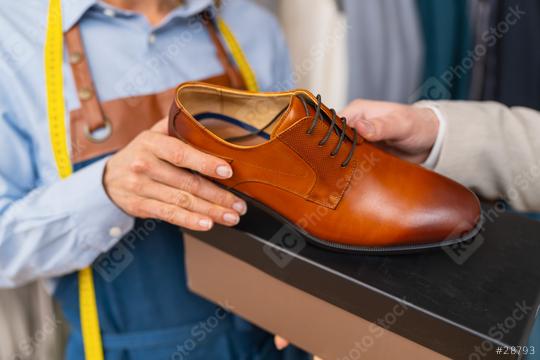 Tailor woman showcasing a brown leather dress shoe beside a box  : Stock Photo or Stock Video Download rcfotostock photos, images and assets rcfotostock | RC Photo Stock.: