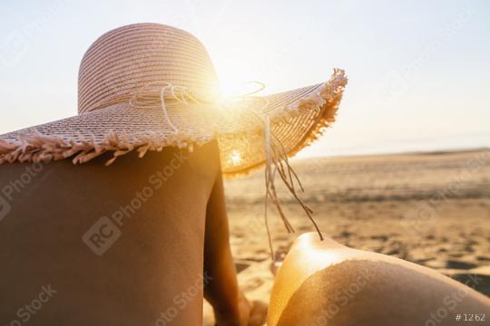tanning woman wearing sun hat over her legs on the beach at sunset  : Stock Photo or Stock Video Download rcfotostock photos, images and assets rcfotostock | RC Photo Stock.: