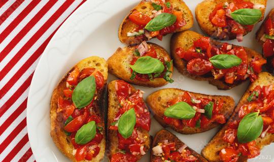 Tasty savory tomato Italian appetizers, or bruschetta, on slices of toasted baguette garnished with basil  : Stock Photo or Stock Video Download rcfotostock photos, images and assets rcfotostock | RC Photo Stock.: