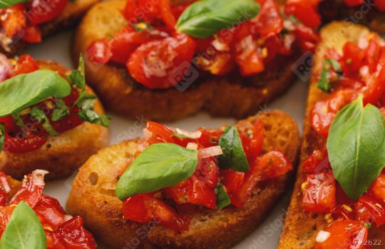 Tasty savory tomato Italian appetizers, or bruschetta, on slices of toasted baguette garnished with basil  : Stock Photo or Stock Video Download rcfotostock photos, images and assets rcfotostock | RC Photo Stock.: