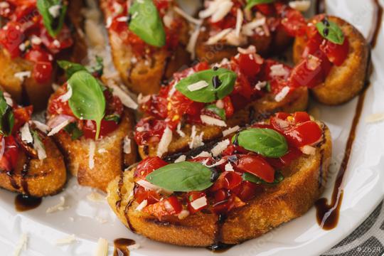 Tasty savory tomato Italian appetizers, or bruschetta, on slices of toasted baguette garnished with basil, close up on a Plate  : Stock Photo or Stock Video Download rcfotostock photos, images and assets rcfotostock | RC Photo Stock.: