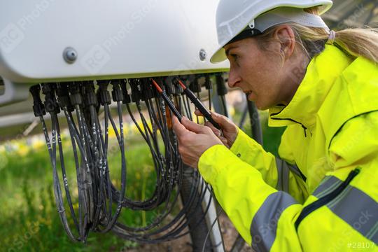 Technician checking solar panel cables with a multimeter in a solarpark field. Alternative energy ecological concept image.  : Stock Photo or Stock Video Download rcfotostock photos, images and assets rcfotostock | RC Photo Stock.: