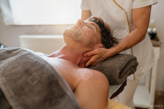Therapist giving a neck massage to a male client in a bright spa room  : Stock Photo or Stock Video Download rcfotostock photos, images and assets rcfotostock | RC Photo Stock.: