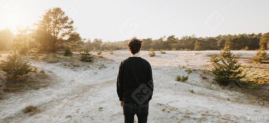 Thoughtful young person from behind on the beach in nature. Surrounded by sand. Relaxed person looks ahead and enjoys life.  : Stock Photo or Stock Video Download rcfotostock photos, images and assets rcfotostock | RC Photo Stock.:
