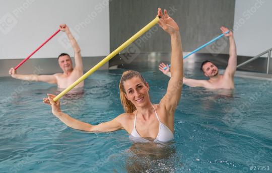 Three adults enjoy a water aerobics class, each holding different colored resistance bars aloft. Sports and gymnastics under water in swimming pool or spa resort.  : Stock Photo or Stock Video Download rcfotostock photos, images and assets rcfotostock | RC Photo Stock.: