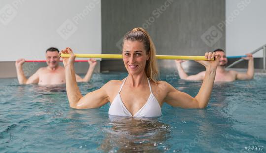 Three people participating in a water aerobics class, smiling and using resistance bars in a pool. Sports and gymnastics under water in spa resort.  : Stock Photo or Stock Video Download rcfotostock photos, images and assets rcfotostock | RC Photo Stock.: