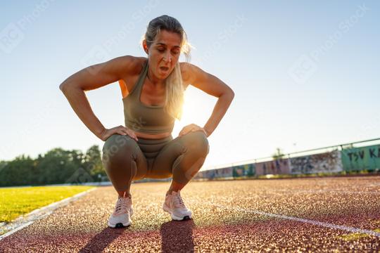 Tired female athlete resting on track field after workout  : Stock Photo or Stock Video Download rcfotostock photos, images and assets rcfotostock | RC Photo Stock.: