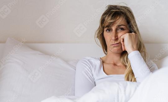 Tired woman Sitting in bed can