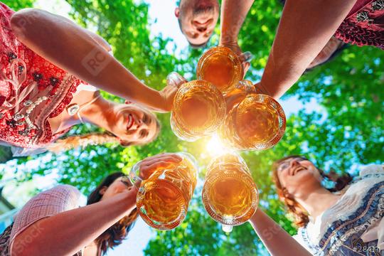 Toasting in Bavarian beer garden. Group of happy friends drinking and toasting beer in Bavarian traditional costume at  Oktoberfest, folk or beer festival, munich, germany  : Stock Photo or Stock Video Download rcfotostock photos, images and assets rcfotostock | RC Photo Stock.: