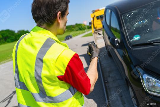 Tow truck operator uses a remote control to load an accident car onto the tow truck  : Stock Photo or Stock Video Download rcfotostock photos, images and assets rcfotostock | RC Photo Stock.: