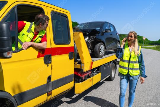 towing service prepares to leave for the workshop while the driver of the vehicle involved in the accident organizes a replacement car using her smartphone.  : Stock Photo or Stock Video Download rcfotostock photos, images and assets rcfotostock | RC Photo Stock.: