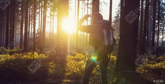 Traveler Man hiking in the woods and looks in to the sunset light - Travel Life Concept image  : Stock Photo or Stock Video Download rcfotostock photos, images and assets rcfotostock | RC Photo Stock.: