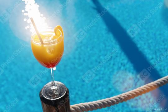 Tropical cocktail, garnished with a orange slice, set against a sparkling blue pool at caribbean island hotel   : Stock Photo or Stock Video Download rcfotostock photos, images and assets rcfotostock | RC Photo Stock.: