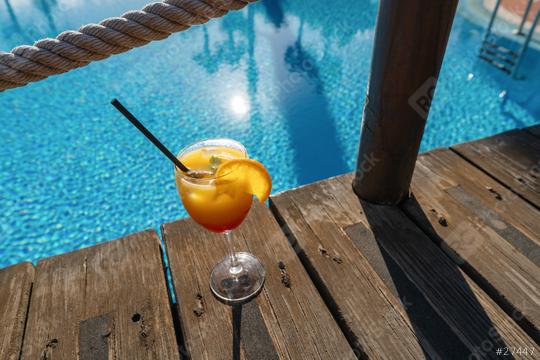 Tropical cocktail on a wooden deck by a pool, featuring a blue water background and rope railing at caribbean island hotel   : Stock Photo or Stock Video Download rcfotostock photos, images and assets rcfotostock | RC Photo Stock.: