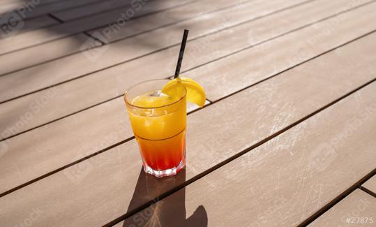 Tropical cocktail with orange slice on wooden deck, sunshine casting shadows, refreshing drink at a caribbean island hotel  : Stock Photo or Stock Video Download rcfotostock photos, images and assets rcfotostock | RC Photo Stock.: