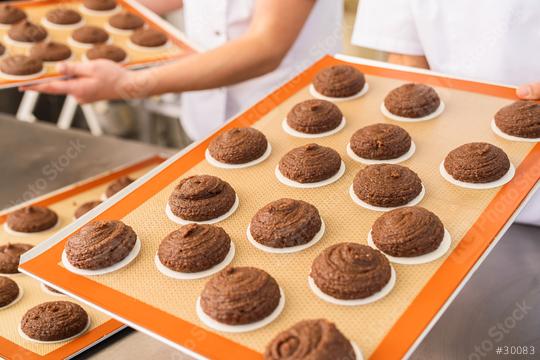 Two bakers hold trays filled with raw gingerbread rounds on baking wafers, prepared for baking in a professional bakery, showcasing the artisanal baking process  : Stock Photo or Stock Video Download rcfotostock photos, images and assets rcfotostock | RC Photo Stock.: